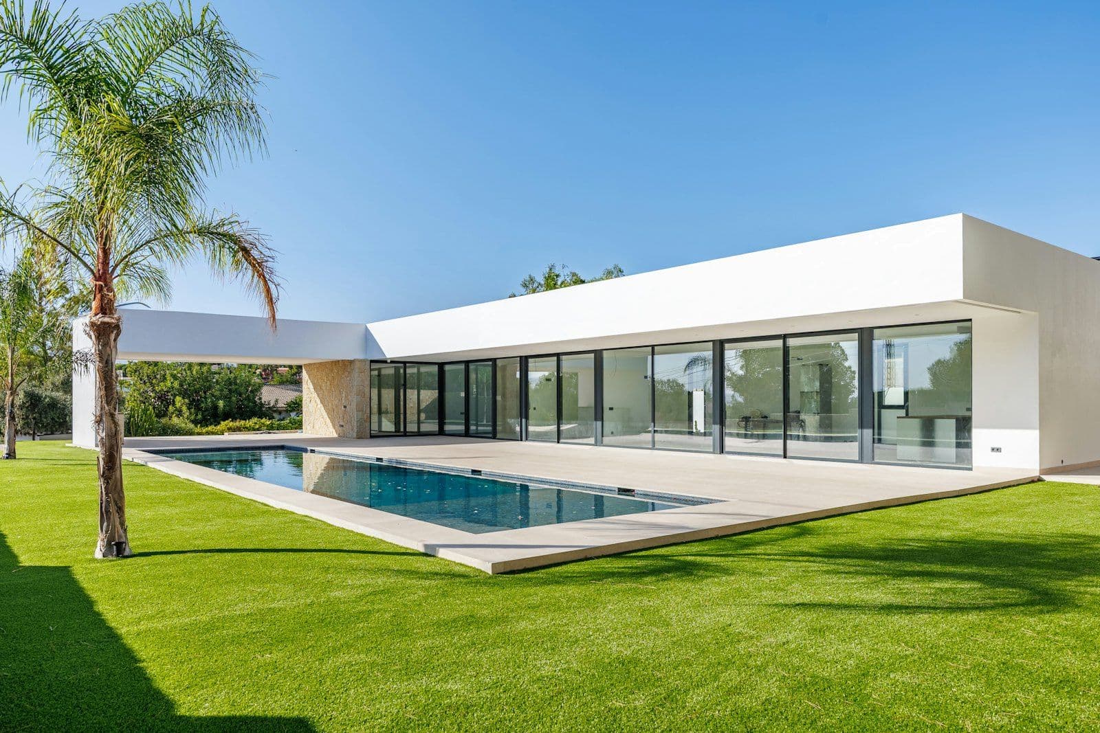 The front elevation of Villa 12, with the pool and garden